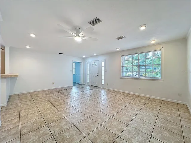 an empty room with windows and fan