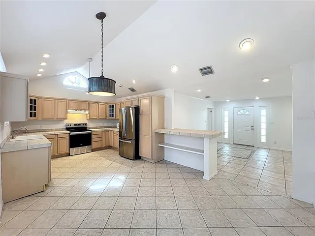 a kitchen with granite countertop a refrigerator and a sink