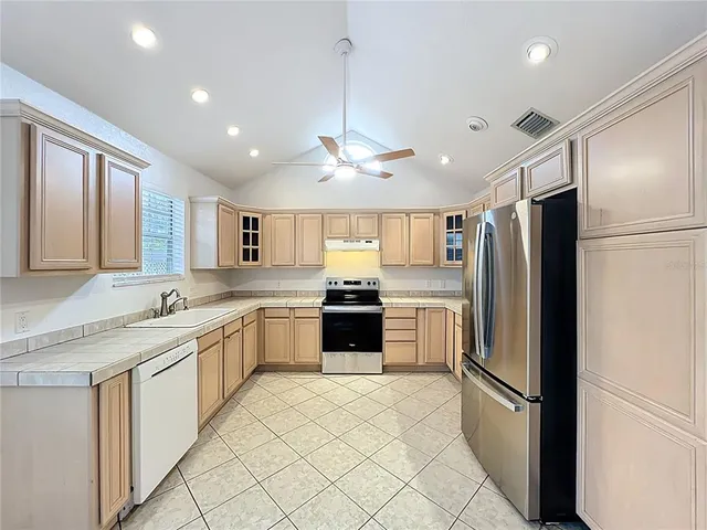 a kitchen with stainless steel appliances granite countertop a refrigerator and a sink