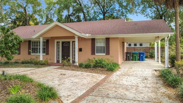 a front view of a house with a yard and potted plants