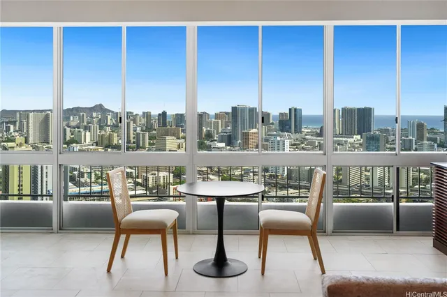 a view of a city from a chairs and table in the balcony
