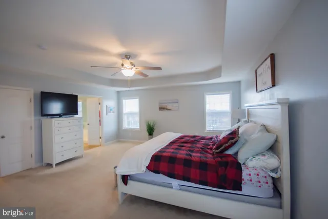 a bedroom with furniture and a chandelier fan