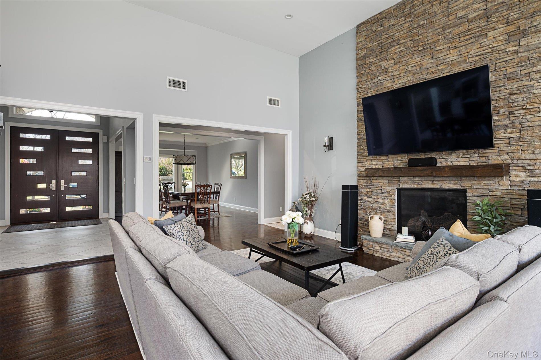 7 Riga Lane Melville, NY 11747 - Photo 12 of 33 a living room with furniture a flat screen tv and a fireplace