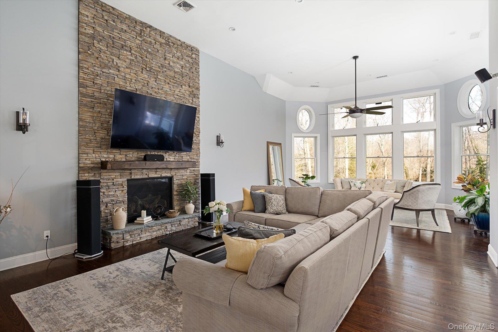 7 Riga Lane Melville, NY 11747 - Photo 9 of 33 a living room with furniture a flat screen tv and a fireplace