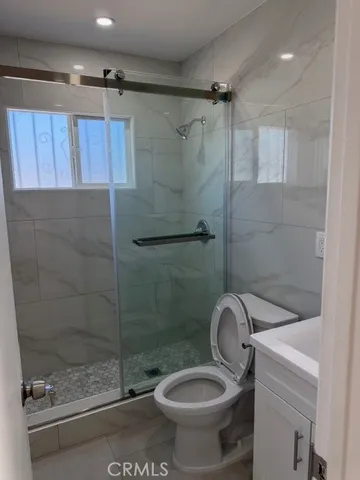 a bathroom with a shower a toilet and sink
