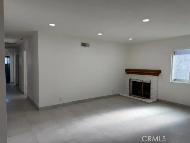 an empty room with a fireplace and wooden floor