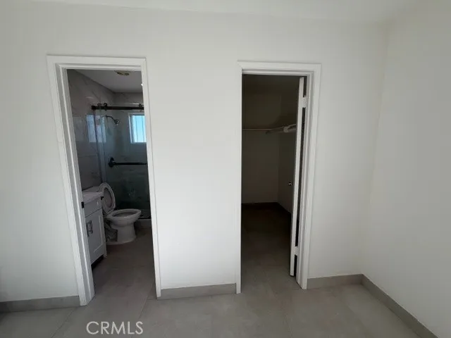 a view of a hallway with closet and a bathroom