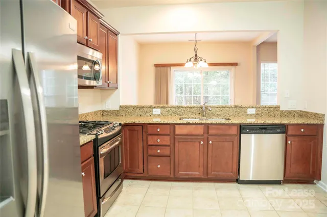 a kitchen with stainless steel appliances granite countertop a refrigerator and a sink