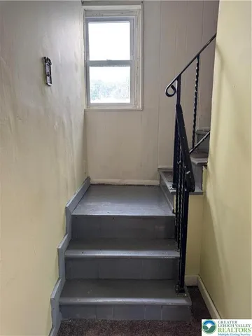a view of staircase with white walls and a window