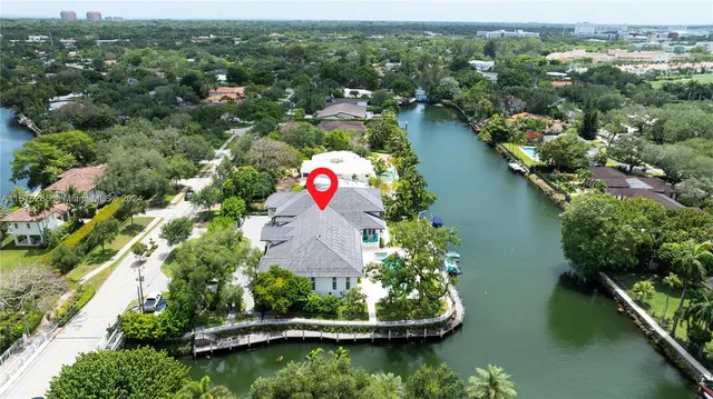 an aerial view of a house with a yard and lake view