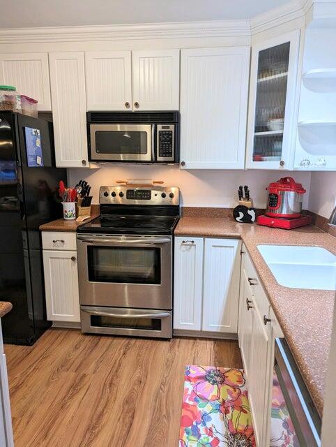1202 East Madison Avenue Stuart, FL 34996 - Photo 5 of 23 a kitchen with stainless steel appliances a stove microwave and cabinets