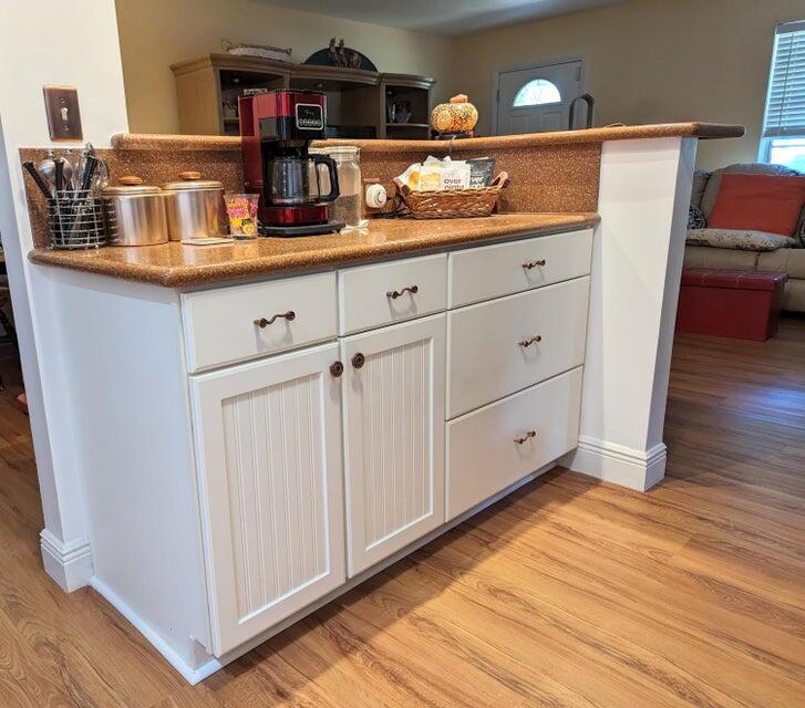 1202 East Madison Avenue Stuart, FL 34996 - Photo 6 of 23 a kitchen with granite countertop white cabinets and wooden floor