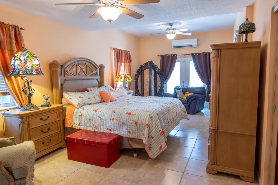 1202 East Madison Avenue Stuart, FL 34996 - Photo 8 of 23 a bedroom with a bed and a chandelier