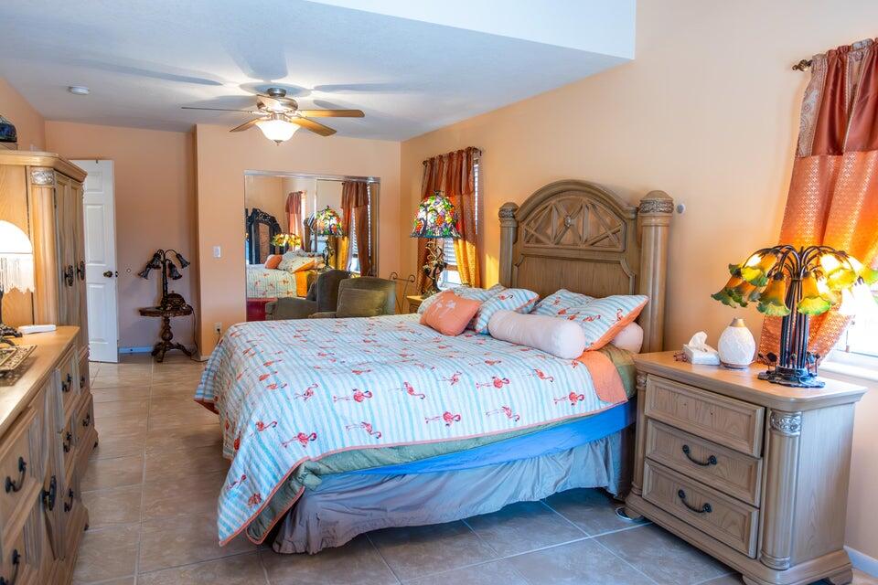 1202 East Madison Avenue Stuart, FL 34996 - Photo 9 of 23 a bedroom with a bed and a chandelier