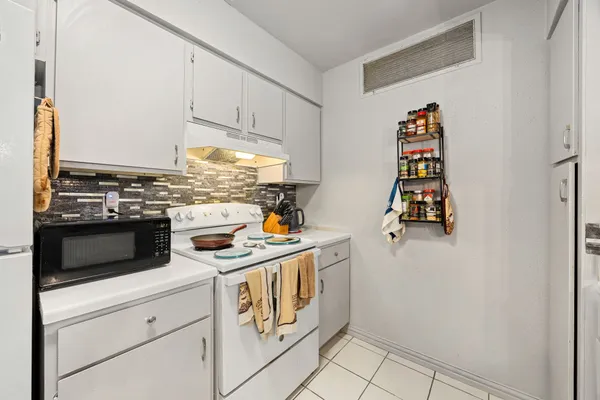 a kitchen with stainless steel appliances granite countertop a sink and a refrigerator