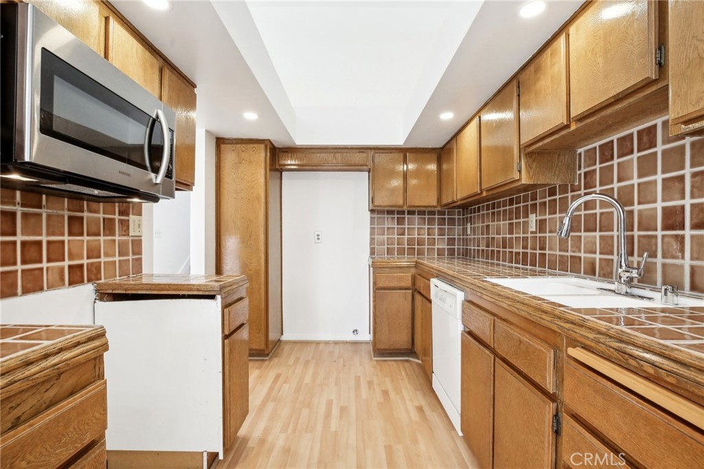 735 Wingate Bay, Unit 50 Costa Mesa, CA 92626 - Photo 12 of 32 a view of a kitchen with a sink and a refrigerator