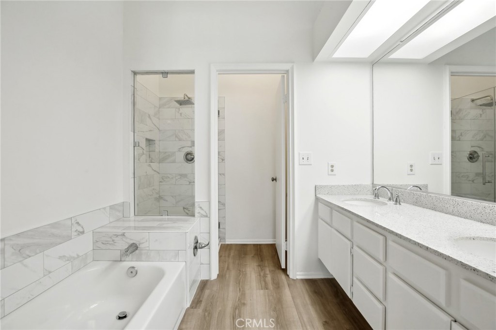 735 Wingate Bay, Unit 50 Costa Mesa, CA 92626 - Photo 23 of 32 a bathroom with a granite countertop sink a toilet and shower