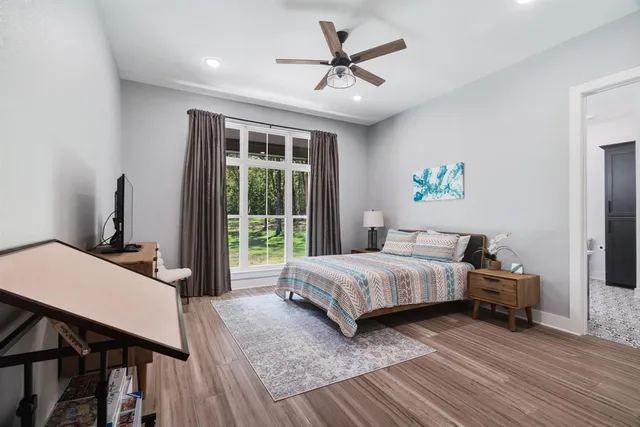 a bedroom with a bed a table and a potted plant