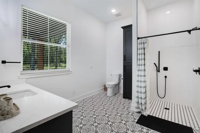 a bathroom with a sink toilet and shower