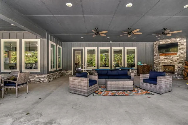 a living room with furniture fireplace and large windows
