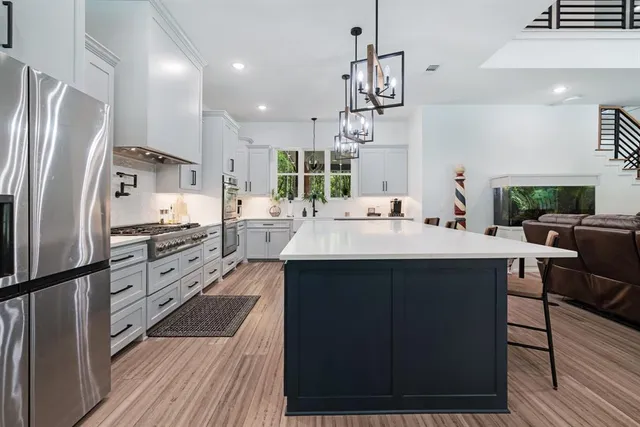 a kitchen with stainless steel appliances a sink cabinets and wooden floor