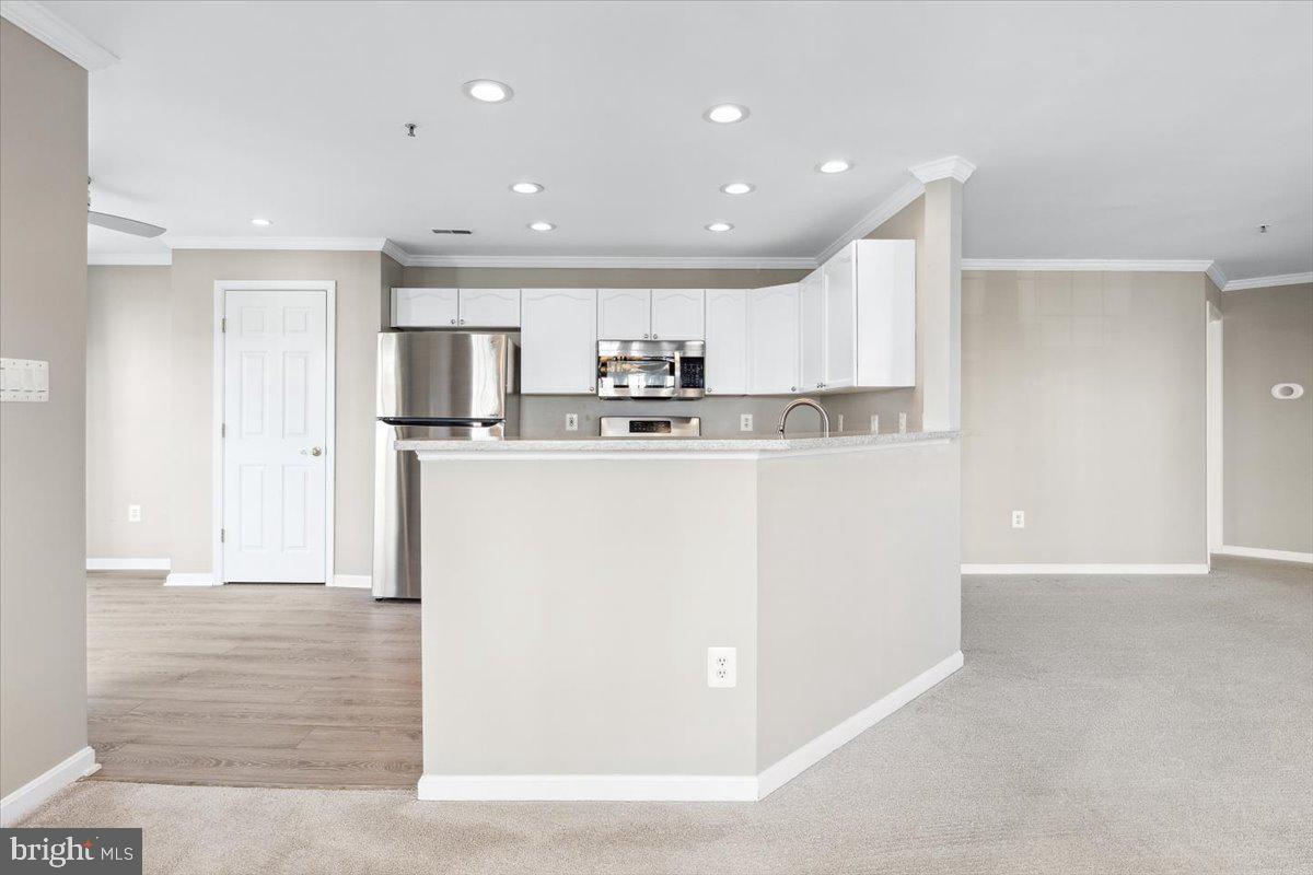 599 Cawley Drive, Unit 2A Frederick, MD 21703 - Photo 15 of 32 a kitchen with stainless steel appliances granite countertop a refrigerator sink and cabinets