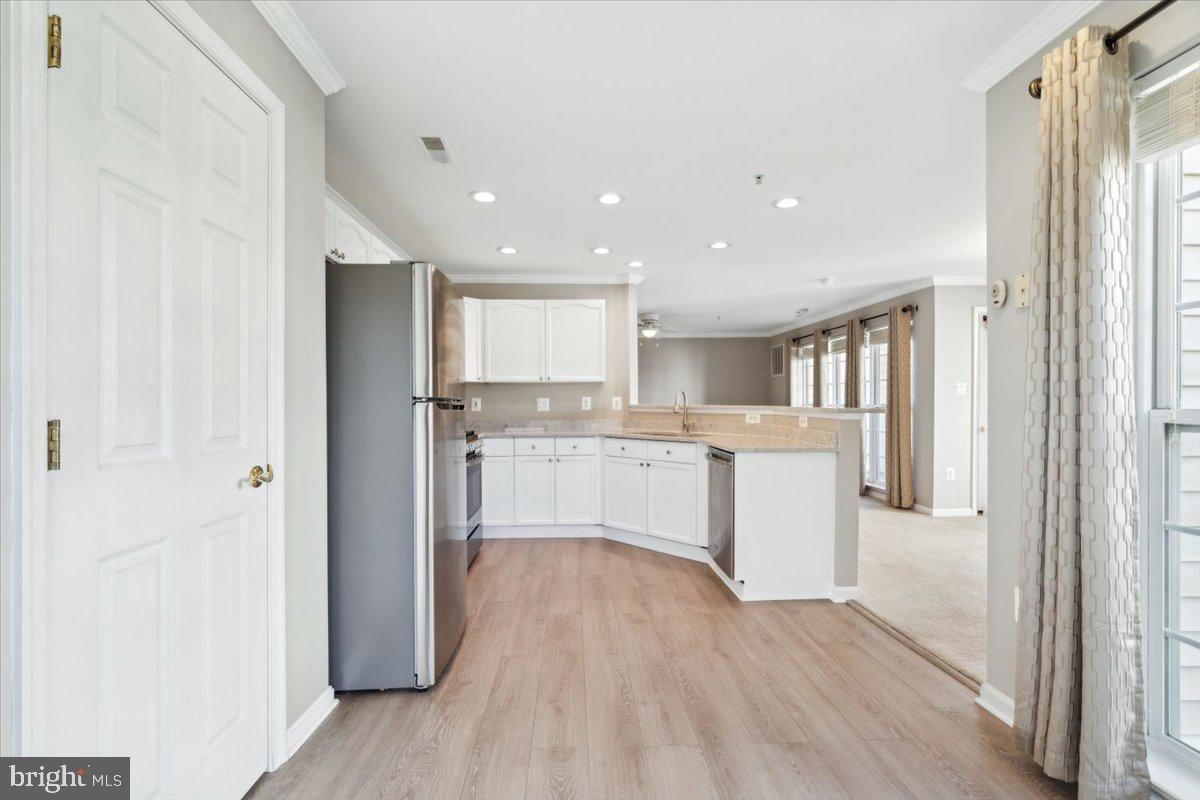 599 Cawley Drive, Unit 2A Frederick, MD 21703 - Photo 18 of 32 a kitchen with white cabinets and wooden floor