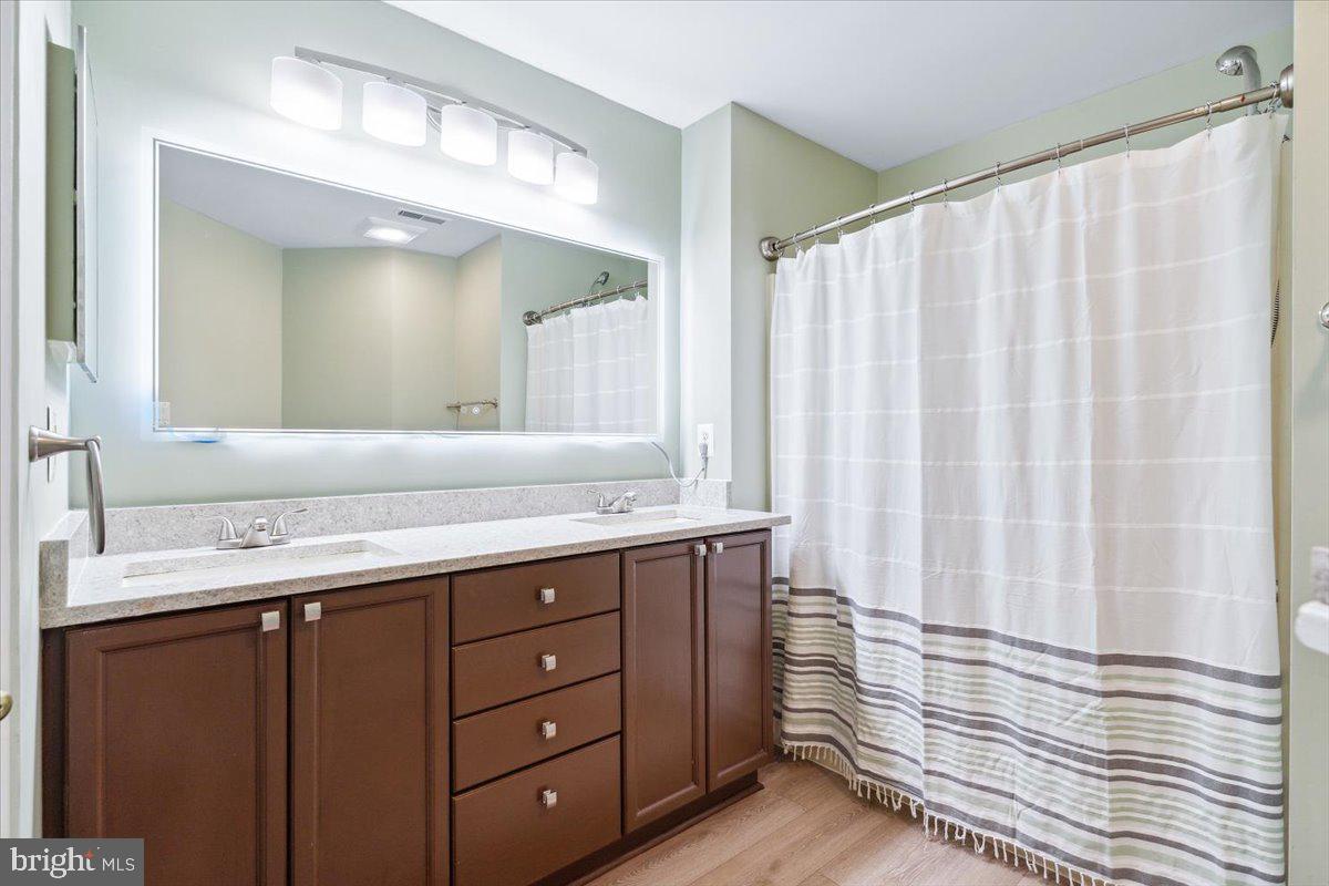 599 Cawley Drive, Unit 2A Frederick, MD 21703 - Photo 29 of 32 a bathroom with a double vanity sink and a mirror