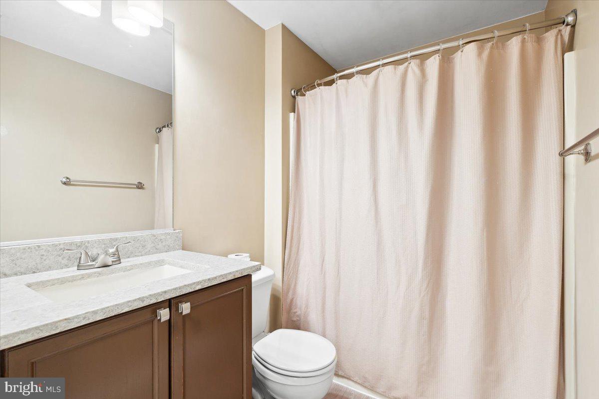 599 Cawley Drive, Unit 2A Frederick, MD 21703 - Photo 8 of 32 a bathroom with a sink a toilet and shower curtain