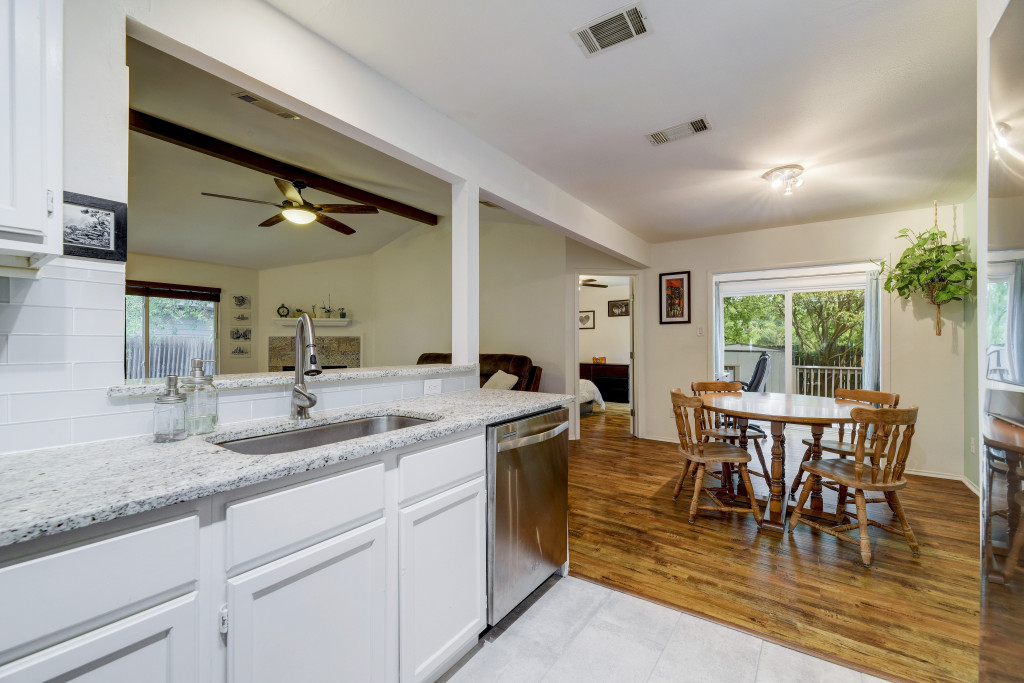 6002 Baton Rouge Drive Austin, TX 78727 - Photo 11 of 20 Kitchen featuring white cabinetry, a stainless steel sink, and light-toned countertops