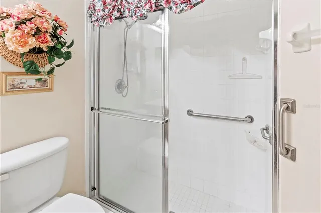 a white toilet sitting next to a shower
