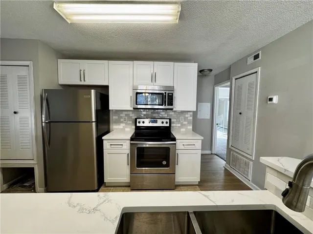 a kitchen with a refrigerator stove and microwave