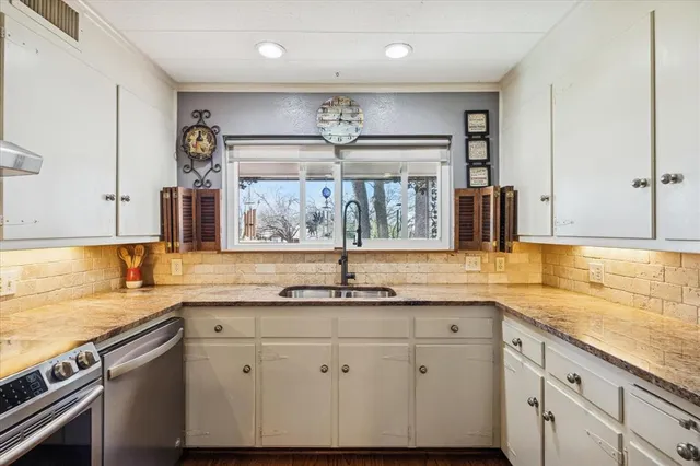 a kitchen with stainless steel appliances granite countertop a sink and a stove