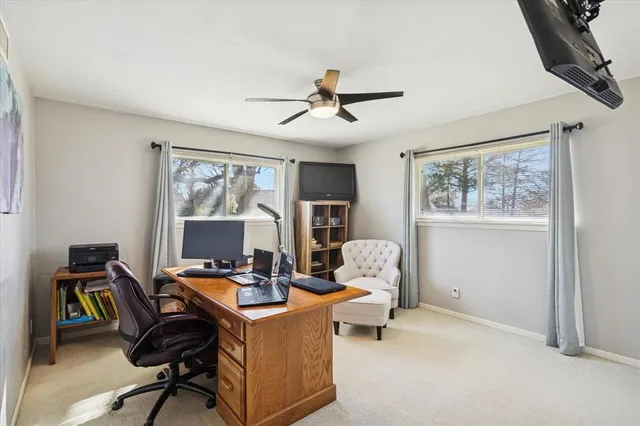 a view of a workspace with furniture and a window