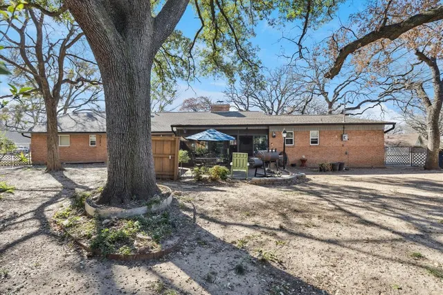 a view of a house with backyard space and a tree
