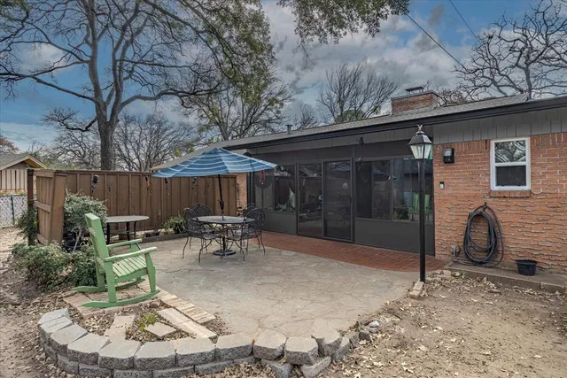 a view of a patio with table and chairs with wooden fence and a couch