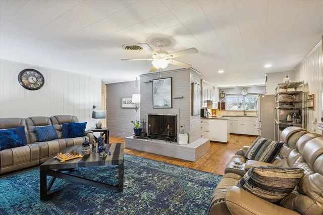 a living room with furniture kitchen view and a fireplace