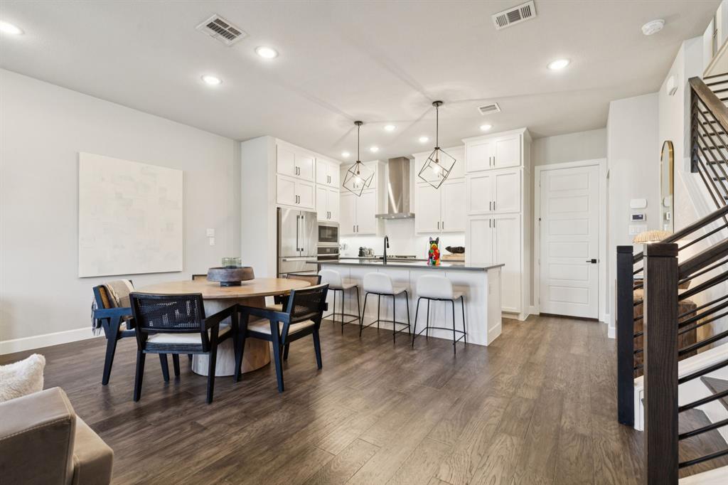 7121 Laurel Ridge Dallas, TX 75231 - Photo 11 of 25 a open dining room with kitchen island stainless steel appliances wooden floor dining table and chairs