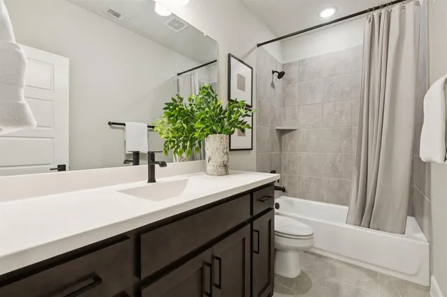 a bathroom with a sink a toilet a mirror and shower