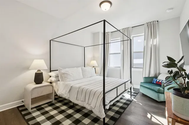 a bedroom with a bed and a potted plant