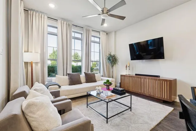 a living room with furniture a flat screen tv and a window