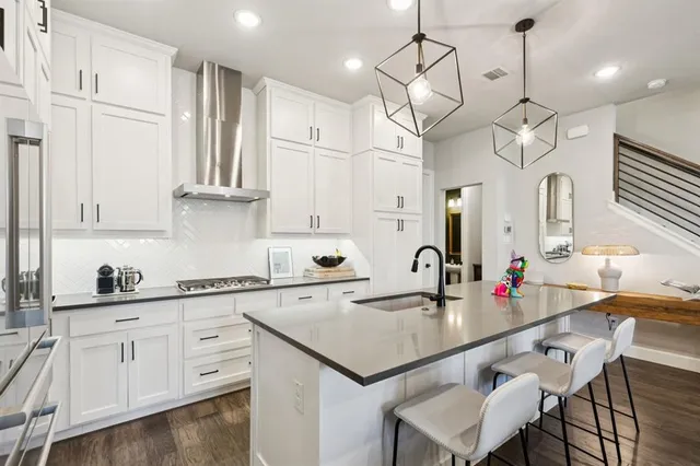 a kitchen with kitchen island granite countertop a sink a center island and cabinets