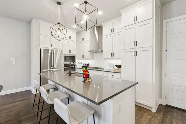 a kitchen with stainless steel appliances granite countertop a stove a refrigerator and a refrigerator