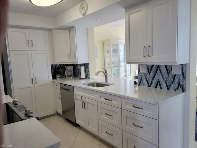 a kitchen with white cabinets and sink