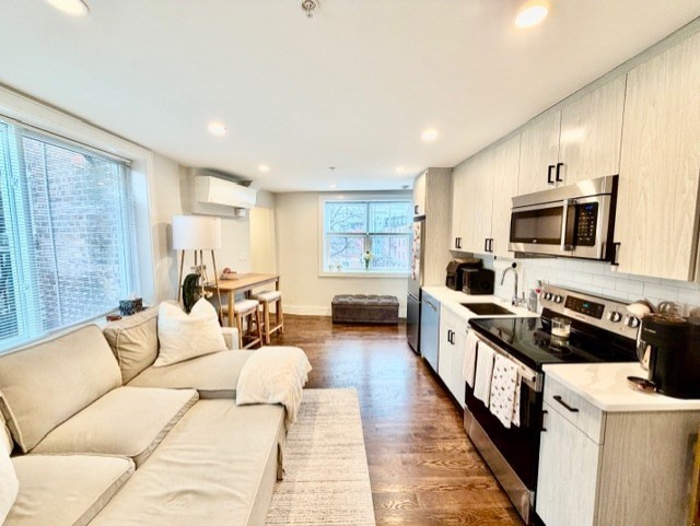 366 Hanover Street, Unit 4 Boston, MA 02113 - Photo 6 of 14 a living room with furniture a rug kitchen view and a window