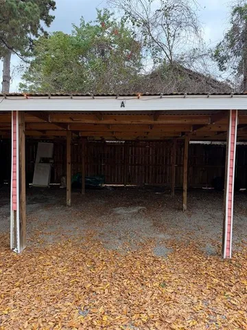 a view of backyard with wooden fence and large trees
