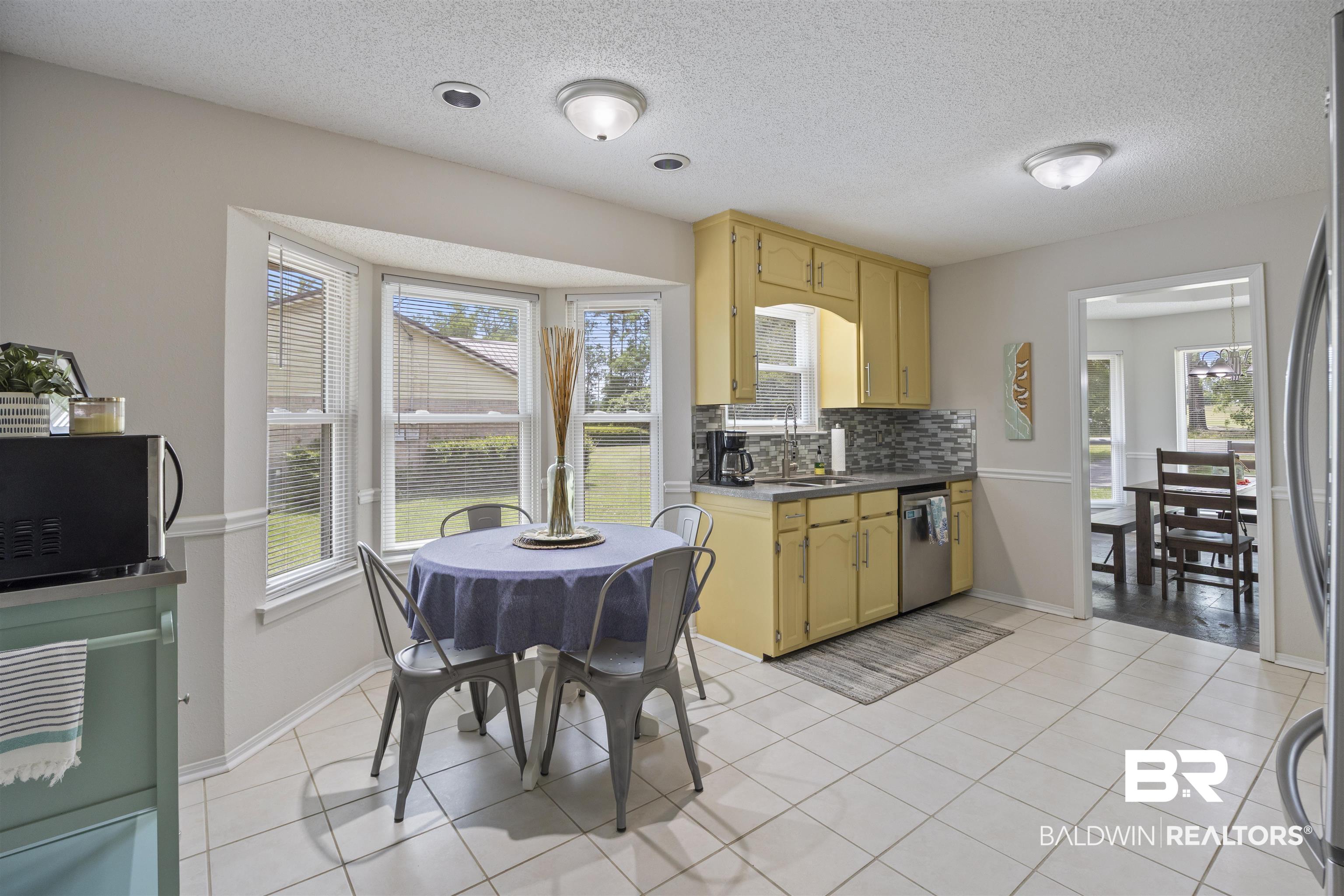 9771 Clarke Ridge Road Foley, AL 36535 - Photo 29 of 72 Kitchen featuring a textured ceiling, appliances with stainless steel finishes, and decorative backsplash.