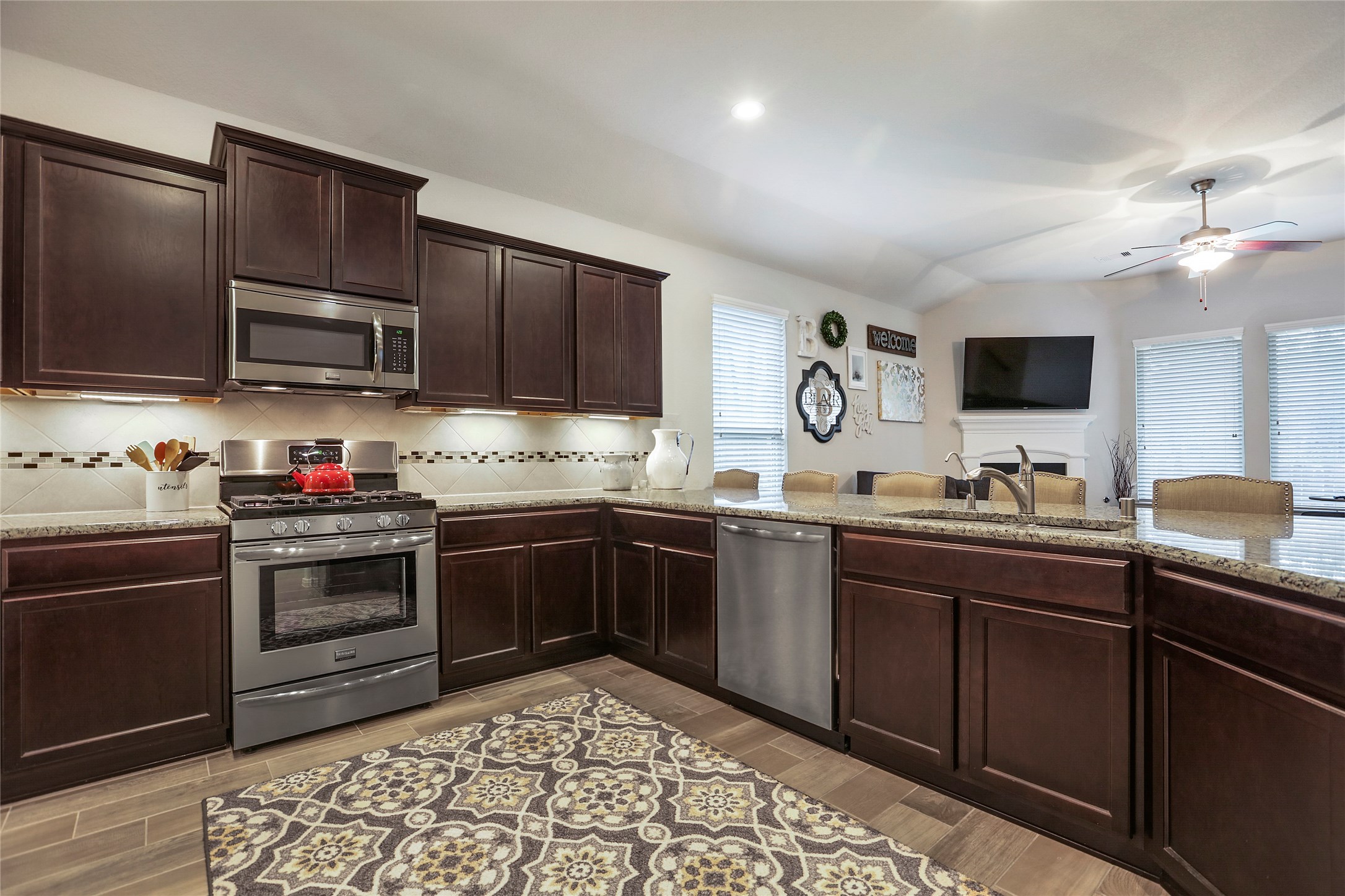 14141 Isle Royal Lane Conroe, TX 77384 - Photo 11 of 39 a kitchen with stainless steel appliances granite countertop a stove top oven a sink dishwasher and a microwave oven with cabinets