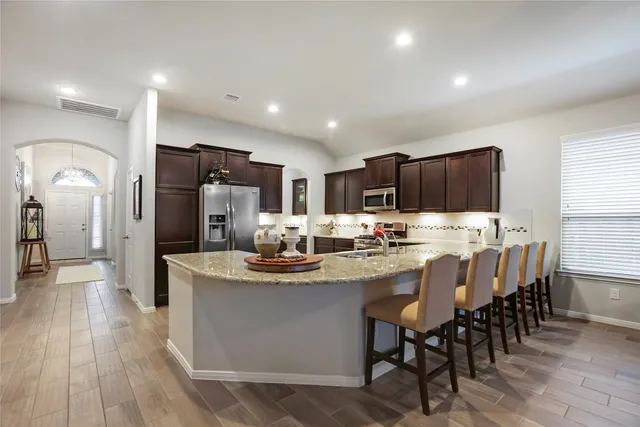 a view of kitchen with granite countertop cabinets table and chairs