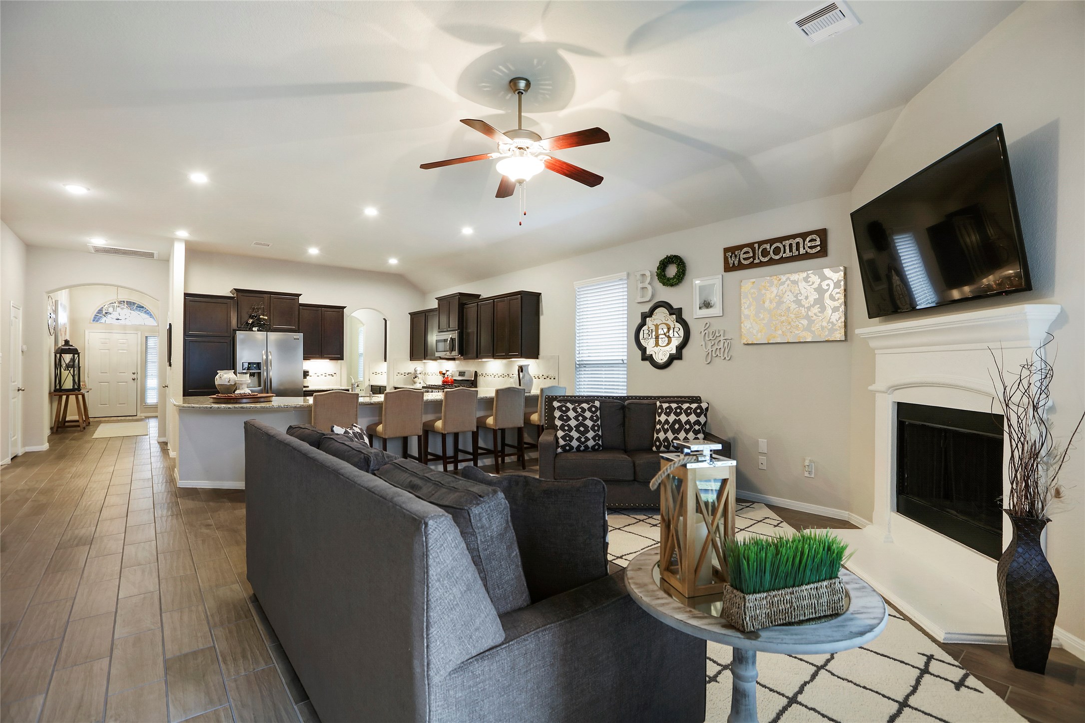 14141 Isle Royal Lane Conroe, TX 77384 - Photo 19 of 39 a kitchen with stainless steel appliances kitchen island granite countertop a stove and a fireplace